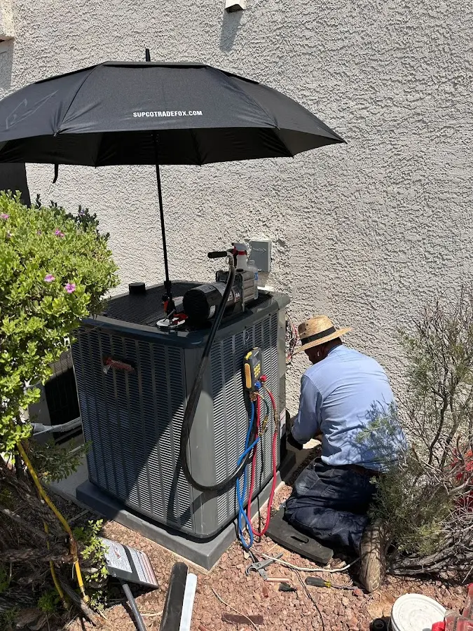 HVAC technician performing outdoor AC maintenance in Tulsa