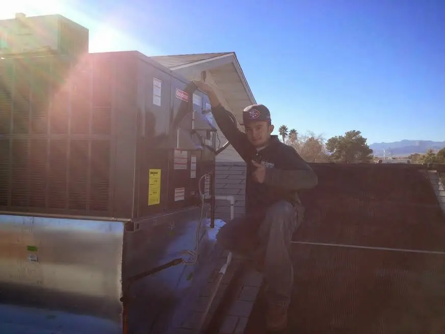 HVAC technician performing Air Duct Cleaning on a rooftop unit in Tulsa